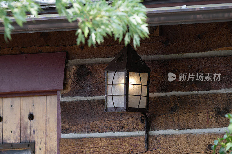 原木建筑上的古董户外灯