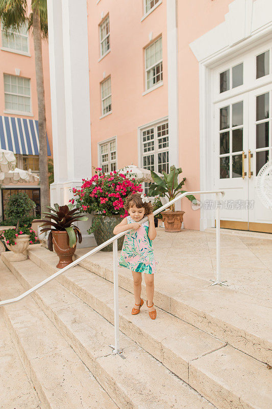 2022年春天，佛罗里达棕榈滩，3岁的幼童穿着热带桃色的宽松连衣裙，为复活节做准备