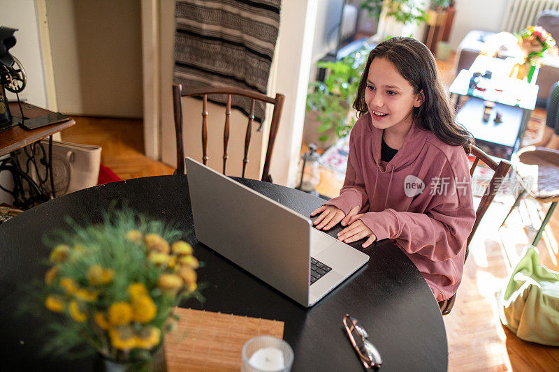 女孩在家里用笔记本电脑进行视频通话