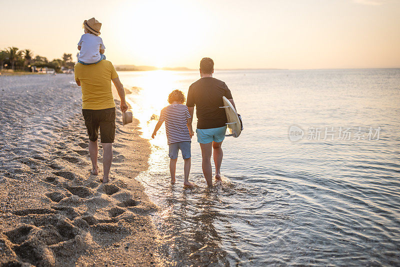 几代同堂的家庭一起沿着海滩散步