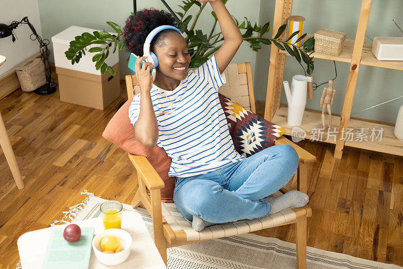 非裔美国年轻女子坐在家里欣赏她最喜欢的音乐