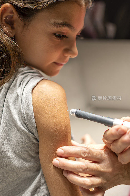 一个漂亮女孩在手臂上注射胰岛素的特写