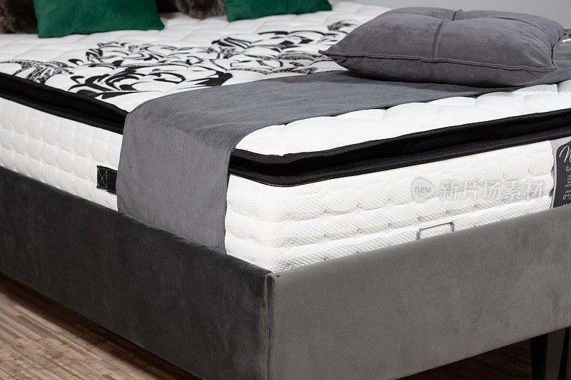 特写镜头的床与灰色的织物内饰，床垫，毯子和靠垫