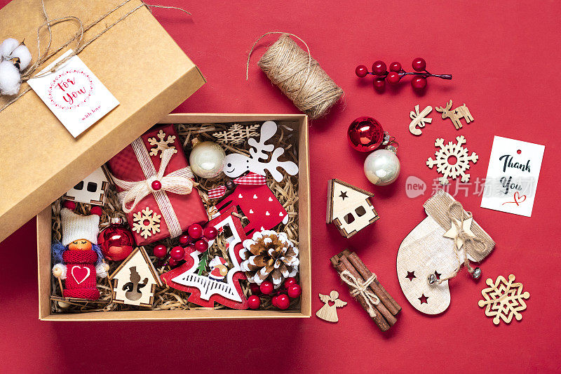 手工关怀包，季节性的礼品盒玩具，圣诞装饰在红色的桌子上，个性化的环保篮子，为家人，朋友，女孩为12月24日，圣诞节，新年的一天平躺
