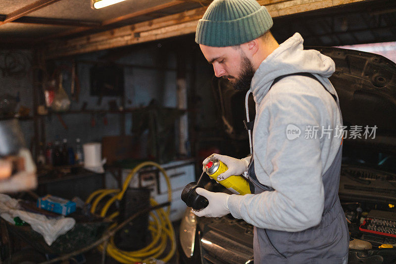 年轻的机械师正在车库里准备更换机油和过滤器