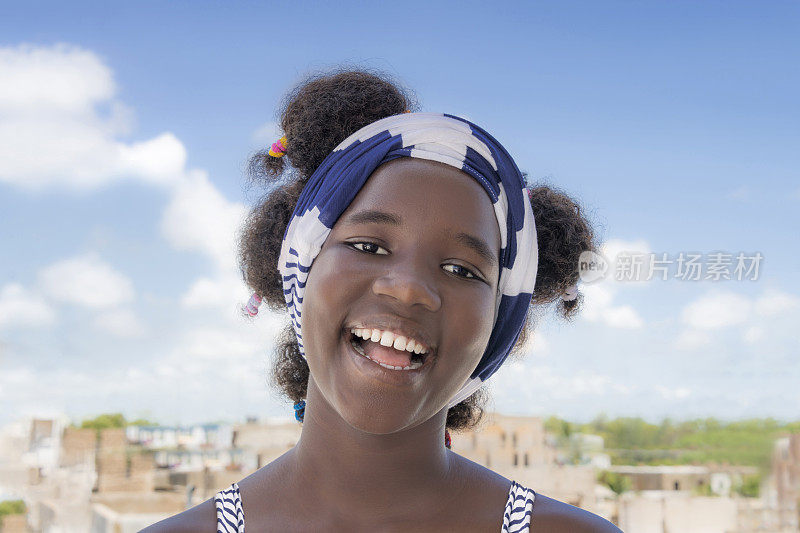 开朗的女孩站在阳台上，非洲发型和辫子，照片