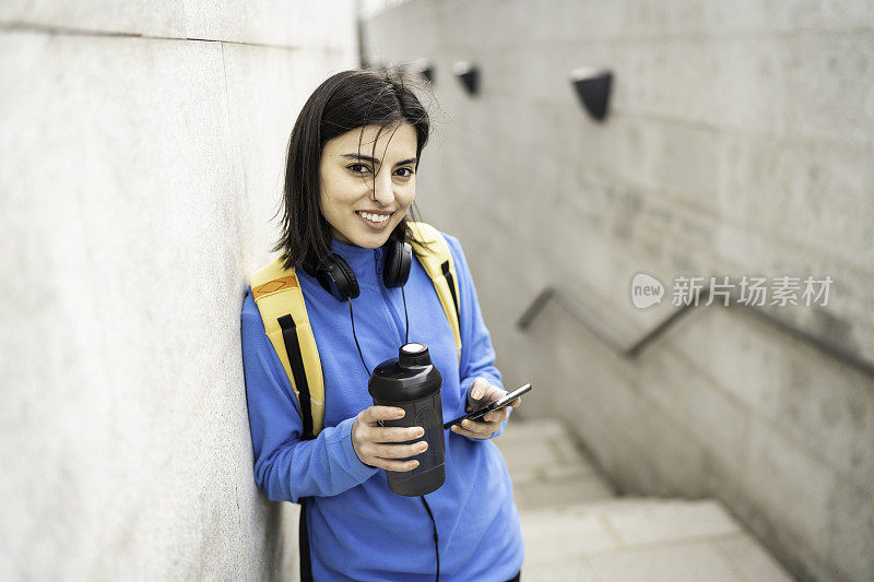 年轻女子在户外运动后喝水