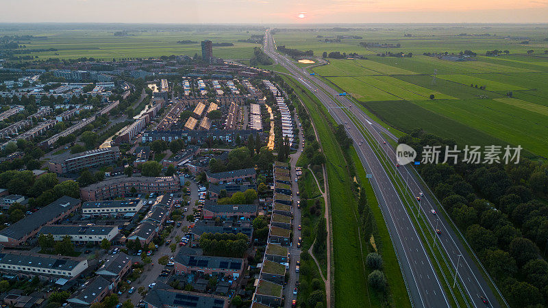 夕阳下阿默斯福特纽兰住宅区的航拍照片，旁边是A1高速公路。