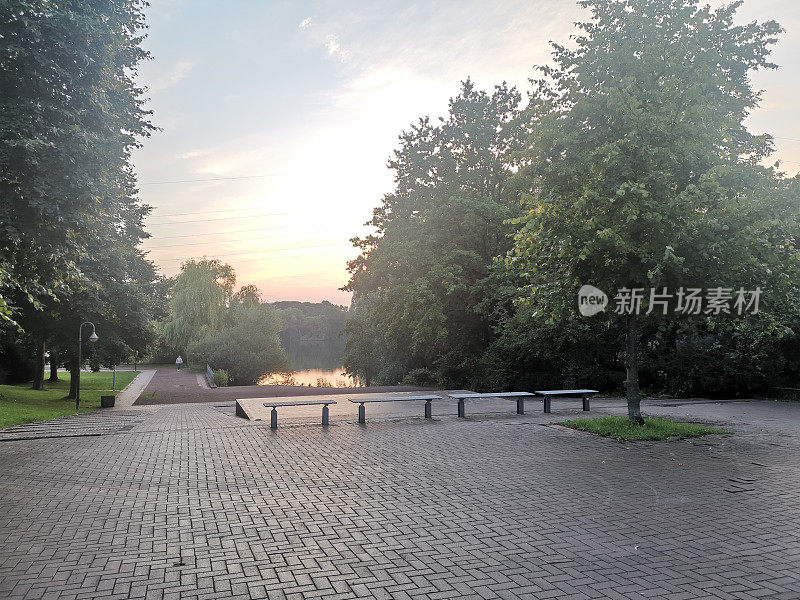 在一个温暖的夏夜，杜塞尔多夫公园的长椅上可以看到湖景