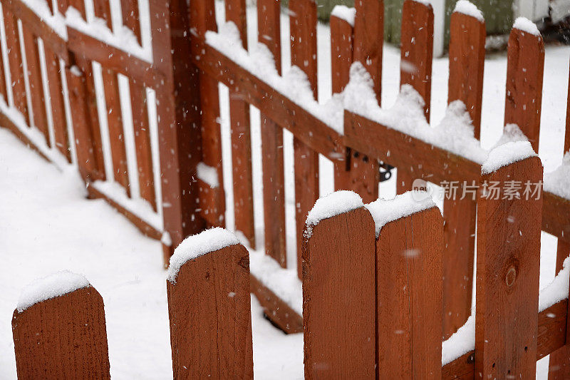 落在木篱笆上的雪