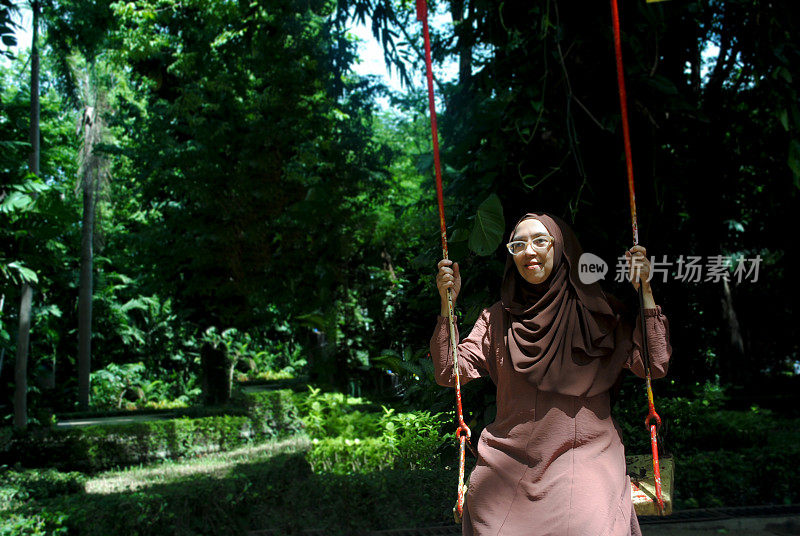 一个女人在自然环境中荡秋千。