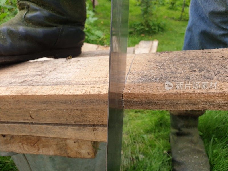 木匠锯板。用钢锯锯木板。