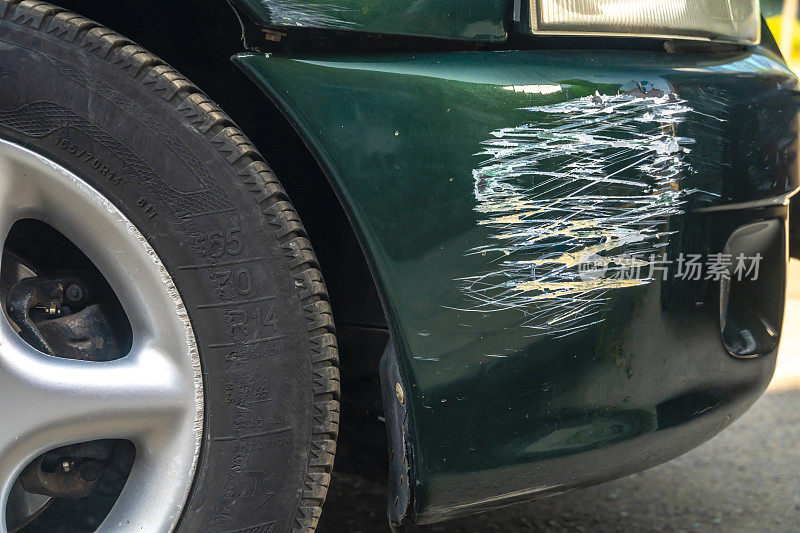 汽车在碰撞事故或停车场中有绿色划痕，油漆受损，金属车身有凹痕