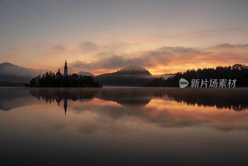 日出时流血的湖-流血的岛屿与太阳的背景和雾蒙蒙的，浪漫的气氛-斯洛文尼亚