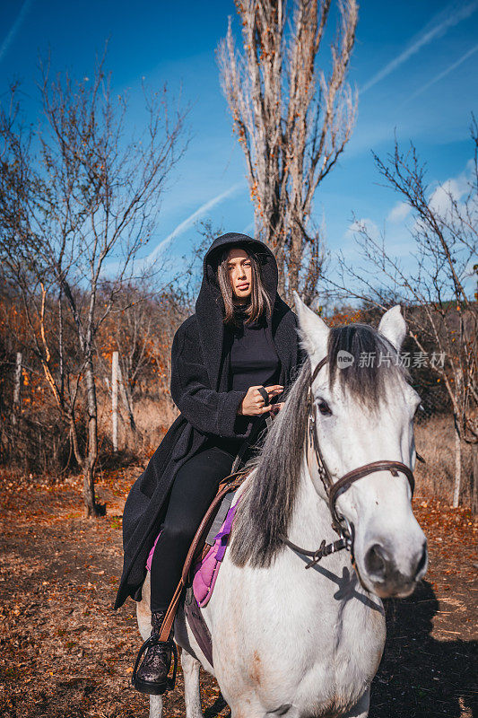 在一个阳光明媚的日子里，一个女人牵着一匹马在牧场上