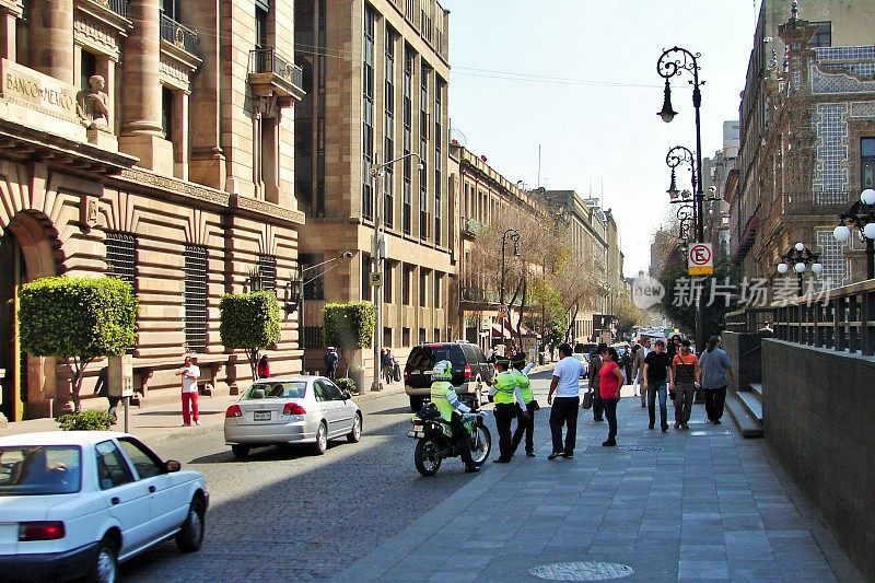 警察和墨西哥银行大楼附近街道上的人们