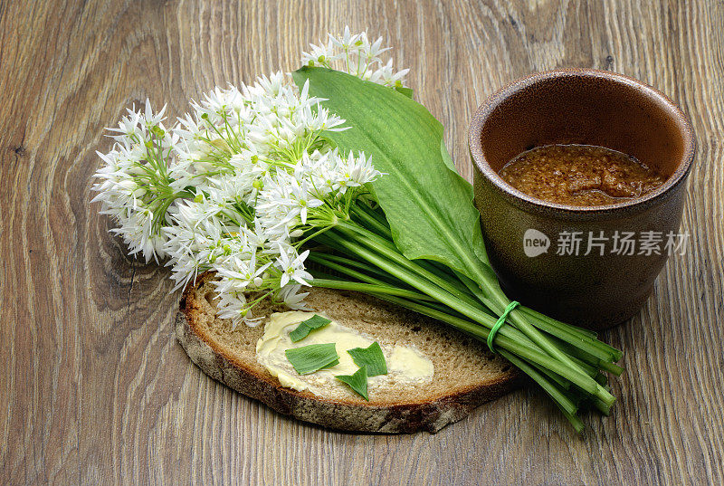 桌上放着一束野蒜叶和黄油面包。锅里放芥末调味。