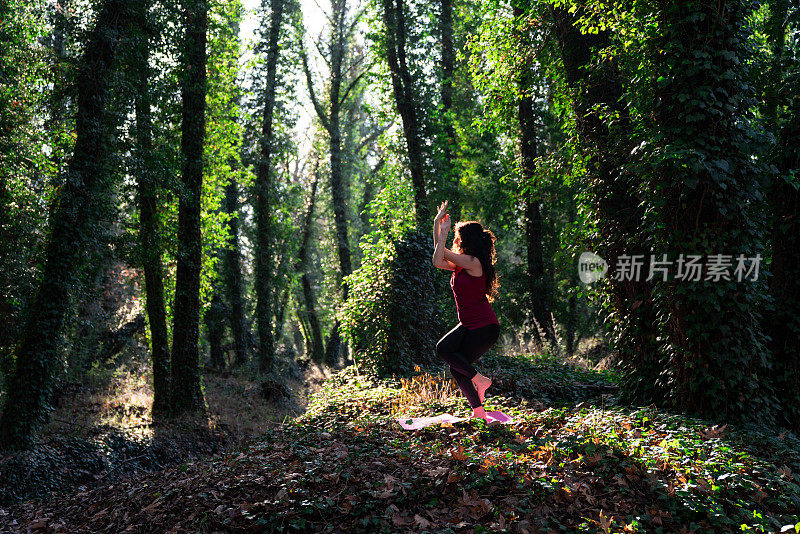 成年妇女在丛林中做瑜伽练习的照片