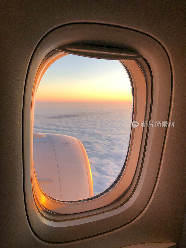 透过飞机窗口观看日落的天空