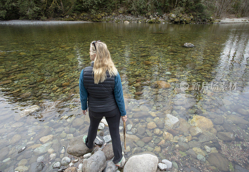 女性徒步旅行者沿着河边行走