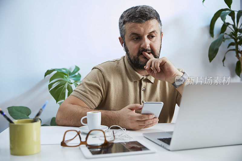 一个年轻人在他的家庭办公室里对着电脑说话