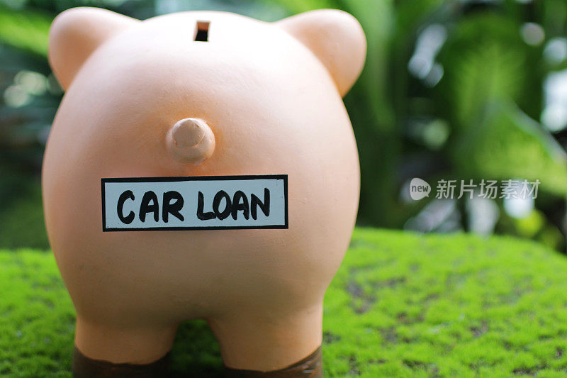 形象的存钱罐尾部与汽车贷款标签，插槽顶部，家庭财务和储蓄的概念