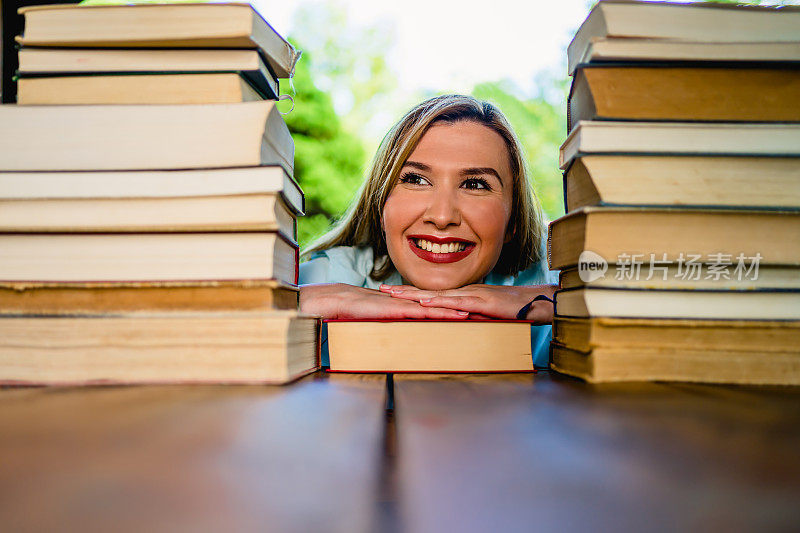 年轻快乐的女人在一堆书中