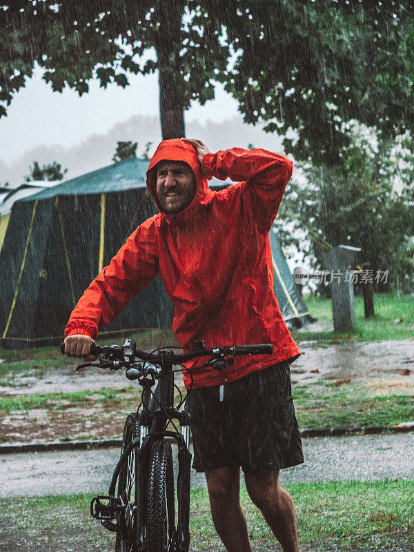 一名山地摩托车手冒着暴雨回来露营