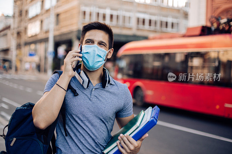 一个戴着面具的学生在去大学的路上打电话的肖像