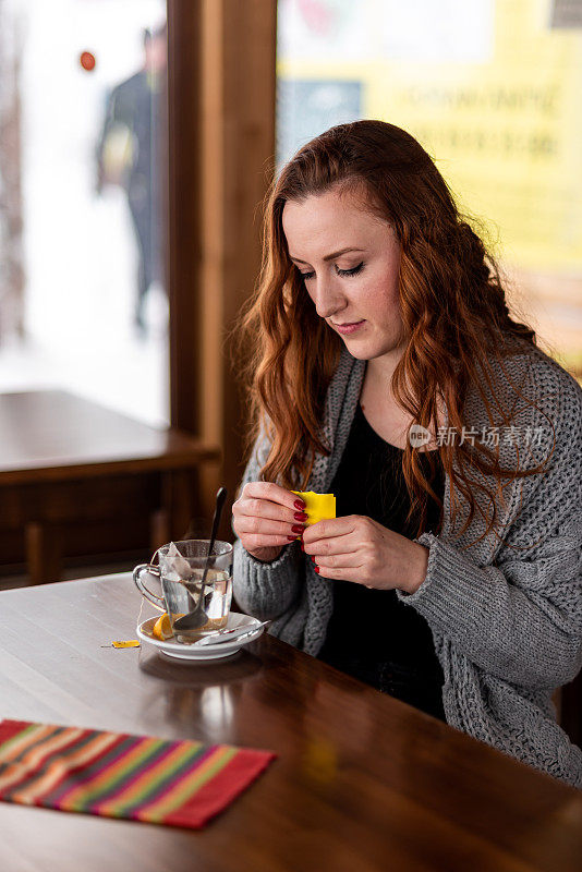 漂亮的年轻女人在咖啡馆喝茶存货照片