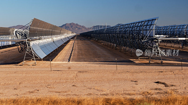 在一个阳光明媚的早晨，抛物线槽太阳能发电厂的镜子之间的视图
