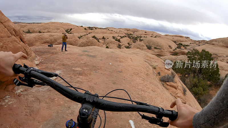 女性山地自行车跟踪在岩石板在早上的踪迹