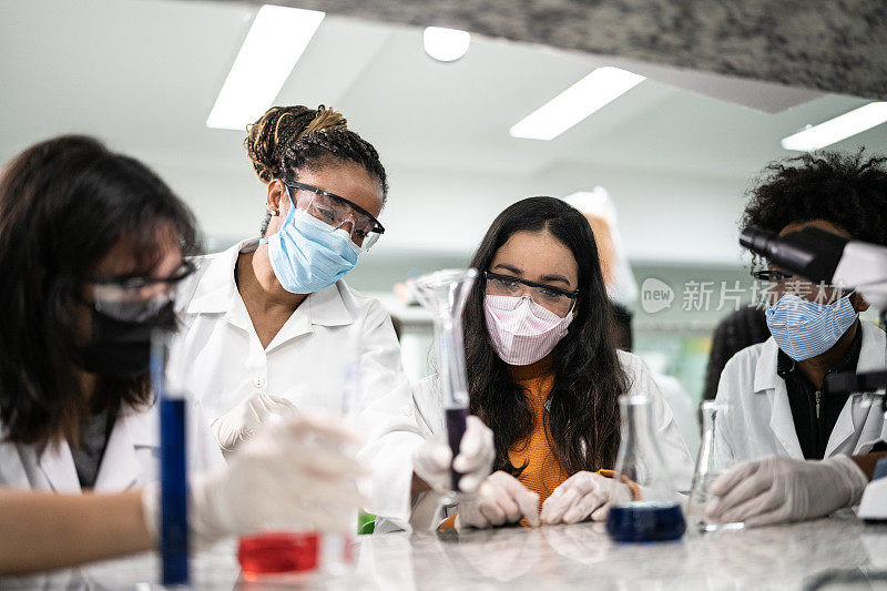 老师在学校或大学的实验室里帮助学生做实验