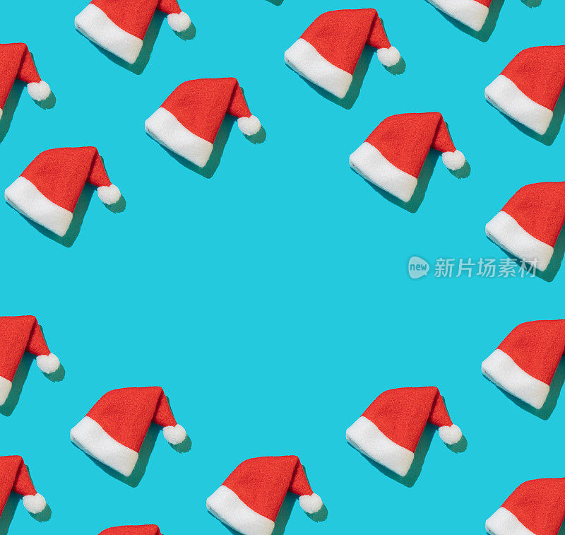 时尚的圣诞图案，圣诞老人的帽子在明亮的亮蓝色背景。最小的圣诞节的概念。