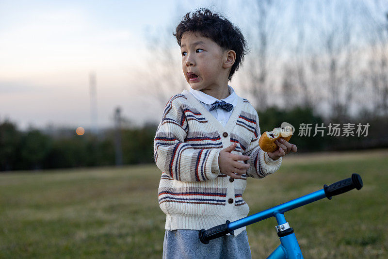 一个男孩正在户外吃面包