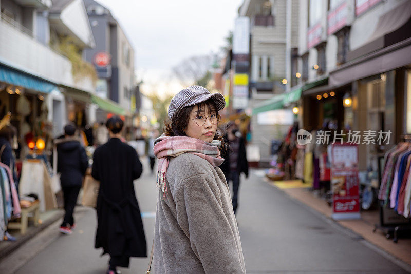 女人走在购物街，在冬天回头看