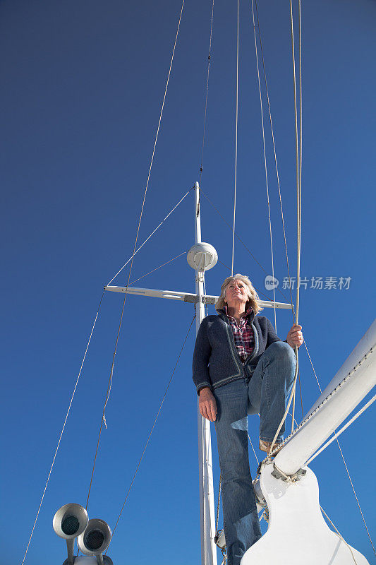中年女水手站在游艇上的索具旁