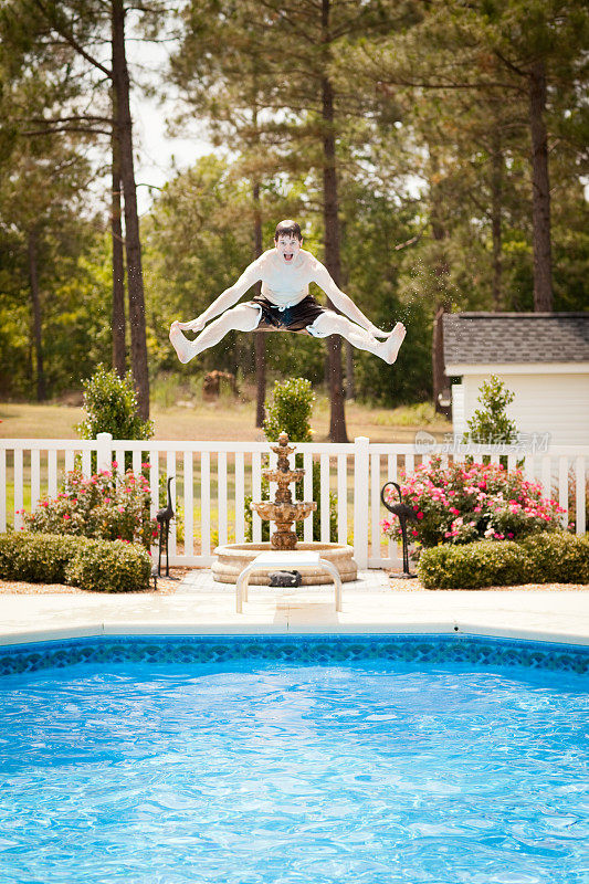 一个男人在跳进游泳池时摸着他的脚趾