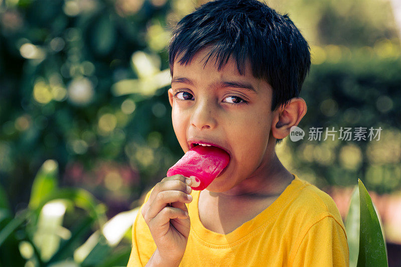 5岁聪明的印度男孩在舔冰棒