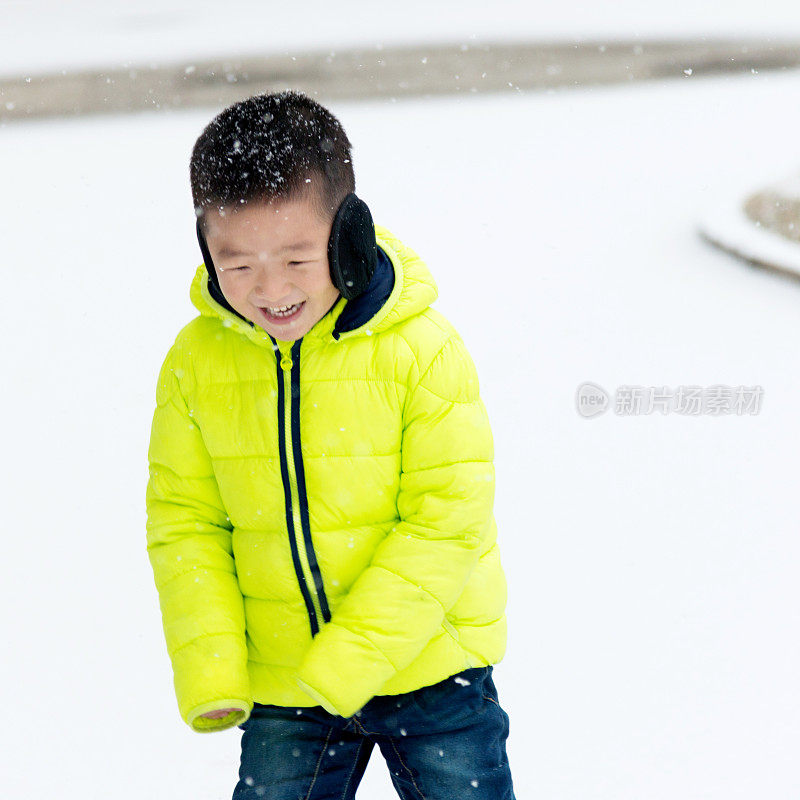 一个亚洲男孩在雪地里玩