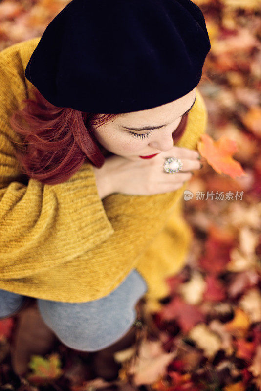 秋叶中美丽的红发女郎。