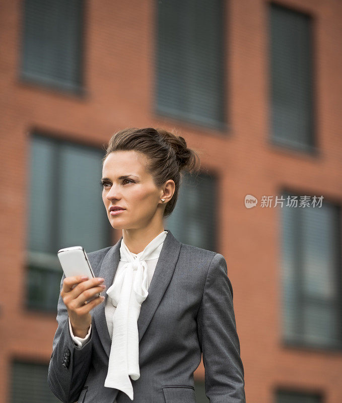 现代商业女性用智能手机对抗办公大楼