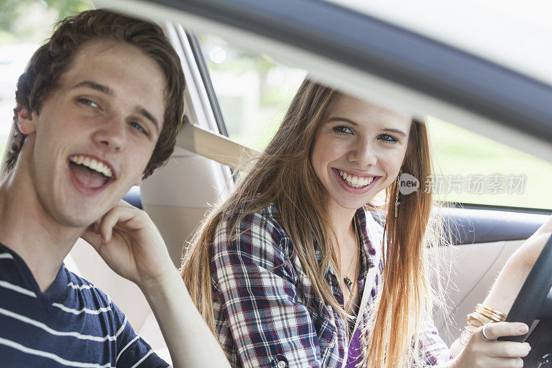 两个青少年在一辆车里，一个女孩开车