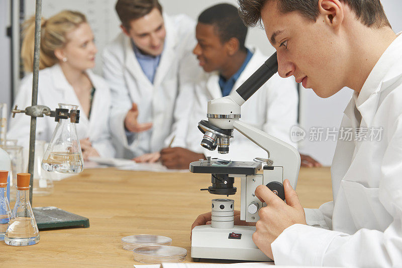 男生在科学课上使用显微镜