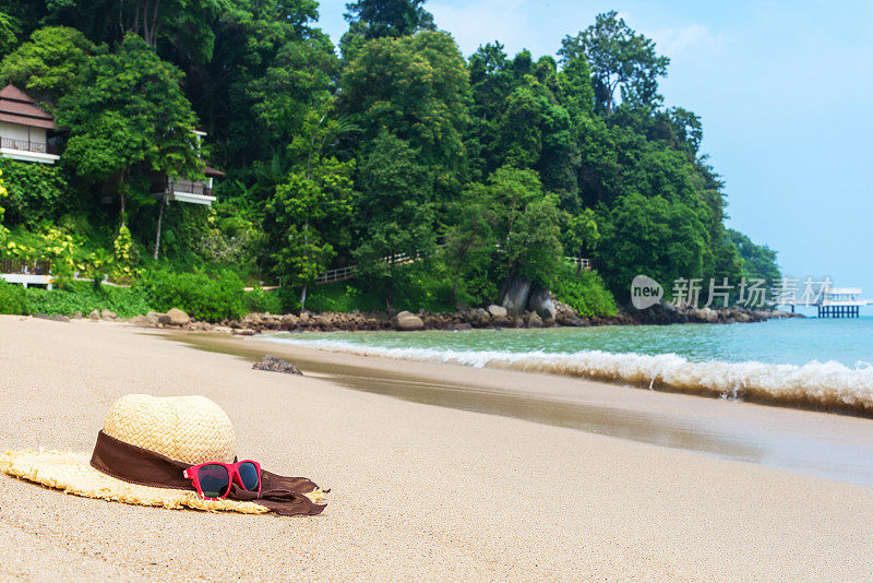 热带海滩上的草帽和太阳镜