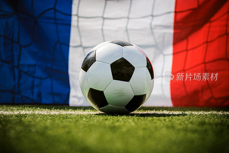 足球在绿色的足球场和法国国旗