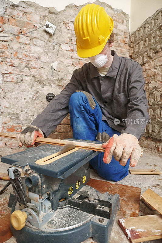 年轻人用小桌子锯工作
