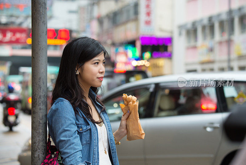 女子香港街头，站在吃传统快餐的招牌上