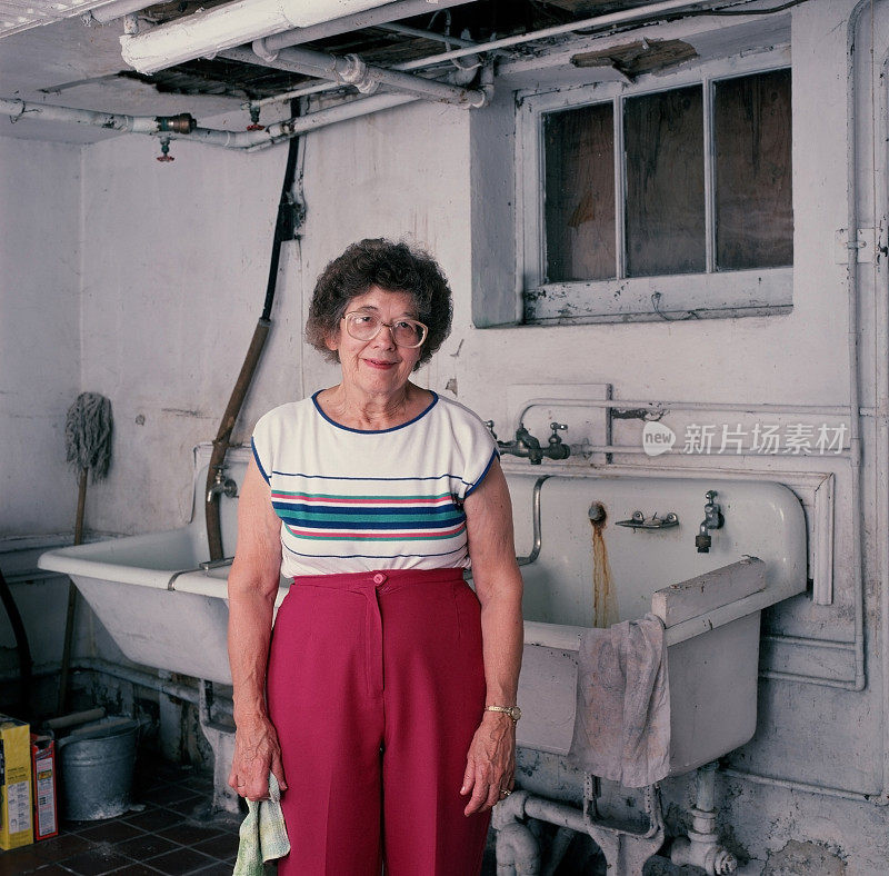 忙碌的老妇人站在洗衣房里