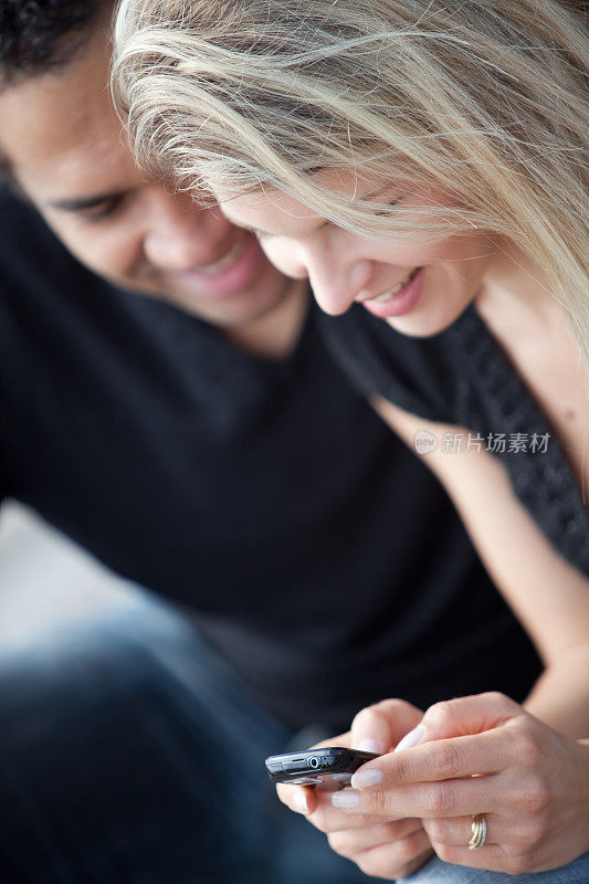 一对年轻夫妇在看手机短信